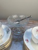 Kaffekoppar med fat, sockertång, ljusstake sockerskål